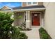 Charming front entrance with a bright red door, decorative plants, and a welcoming atmosphere at 7163 Talamore Dr, Wesley Chapel, FL 33545