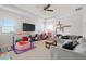 Spacious living room with a ceiling fan, neutral walls, a gray sofa and a variety of toys at 7163 Talamore Dr, Wesley Chapel, FL 33545