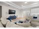 Spacious living room with tray ceiling, large TV, and comfortable seating, perfect for relaxing and entertaining guests at 7163 Talamore Dr, Wesley Chapel, FL 33545