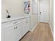 Well-organized mudroom with white cabinets and countertop space, providing a convenient area for storage and organization at 7163 Talamore Dr, Wesley Chapel, FL 33545