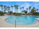 Community pool area with palm trees and comfortable lounge chairs for relaxing at 7163 Talamore Dr, Wesley Chapel, FL 33545