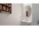 Neutral powder room featuring a pedestal sink, decorative shelf, and oval mirror at 7163 Talamore Dr, Wesley Chapel, FL 33545