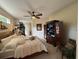 Comfortable main bedroom with a ceiling fan, large window, and decorative accents at 10937 Bluestem Cir, Lakewood Ranch, FL 34202