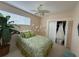 Bedroom features a bed, ceiling fan, closet with wedding dress, and a large window at 10937 Bluestem Cir, Lakewood Ranch, FL 34202
