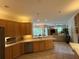 Kitchen open to the living and dining area with a spacious counter, stainless appliances and wood cabinets at 10937 Bluestem Cir, Lakewood Ranch, FL 34202