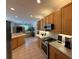 Well-equipped kitchen with tile floors, wood cabinets, modern appliances, and plenty of counter space at 10937 Bluestem Cir, Lakewood Ranch, FL 34202