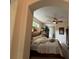 Spacious main bedroom featuring a ceiling fan, plants, and a bed covered with pillows and blankets at 10937 Bluestem Cir, Lakewood Ranch, FL 34202
