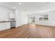Open-concept living room with a stainless dishwasher, and light wooden floors at 11975 Sylvia St, Dade City, FL 33525