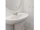 Close-up of a modern white pedestal sink with chrome fixtures in a powder room at 11975 Sylvia St, Dade City, FL 33525