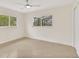 Bright bedroom featuring tiled floor, ceiling fan, and lots of natural light from two windows at 1764 Boca Raton Ct, Punta Gorda, FL 33950