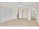 Well-lit bedroom with neutral tile flooring, a ceiling fan, closet, and adjoining bathroom at 1764 Boca Raton Ct, Punta Gorda, FL 33950