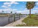 Waterfront view along the canal, enhanced by the presence of a mature palm tree at 1764 Boca Raton Ct, Punta Gorda, FL 33950
