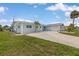 Charming home featuring lush grass, mature palm trees, and a two-car garage at 1764 Boca Raton Ct, Punta Gorda, FL 33950