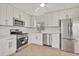 Modern kitchen featuring stainless steel appliances, white cabinets, and tile flooring at 1764 Boca Raton Ct, Punta Gorda, FL 33950