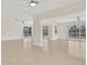 Spacious living room featuring neutral tile flooring, a ceiling fan, and large sliding glass doors at 1764 Boca Raton Ct, Punta Gorda, FL 33950