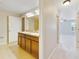 Bathroom featuring double sinks with wood cabinets and tile flooring at 20214 Water Hickory Pl, Tampa, FL 33647