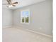 Bright bedroom features neutral carpet, ceiling fan, and window with shutter-style blinds at 20214 Water Hickory Pl, Tampa, FL 33647