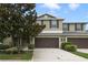 Two-story townhome with brown garage doors, matching shutters and a well-manicured lawn at 20214 Water Hickory Pl, Tampa, FL 33647