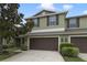 Two-story townhome with brown garage doors, matching shutters and a well-manicured lawn at 20214 Water Hickory Pl, Tampa, FL 33647