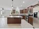 Open kitchen features an island, stainless steel appliances and brown cabinets at 20214 Water Hickory Pl, Tampa, FL 33647