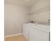Well-lit laundry room with white washer and dryer, and tile flooring at 20214 Water Hickory Pl, Tampa, FL 33647