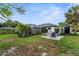 Spacious backyard with fire pit, lush landscaping, and screened-in pool at 2421 Valkaria Ave, North Port, FL 34286