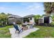 Backyard fire pit with chairs, lush landscaping, and plenty of room for entertaining at 2421 Valkaria Ave, North Port, FL 34286