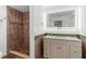 Bathroom features a tile shower and a vanity with a lighted mirror at 2421 Valkaria Ave, North Port, FL 34286