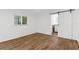 The bedroom has hardwood floors, a window, and a sliding barn door leading to the bathroom at 2421 Valkaria Ave, North Port, FL 34286