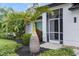 Close-up of the home's entrance with decorative plants and mature landscaping for added curb appeal at 2421 Valkaria Ave, North Port, FL 34286