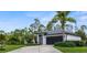 Side view of a one-story home showcasing a well-maintained lawn and lush tropical landscaping at 2421 Valkaria Ave, North Port, FL 34286