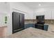 Updated kitchen featuring stainless steel appliances, modern lighting, and blue and white cabinetry at 2421 Valkaria Ave, North Port, FL 34286