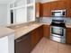 A well-lit kitchen with a breakfast bar, stainless steel appliances and warm wood cabinets at 2936 Banyan Hill Ln, Land O Lakes, FL 34639
