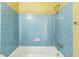 Full bath features blue tiled walls and a tub with shower at 5101 Town N Country Blvd, Tampa, FL 33615