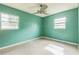 A sunlit bedroom featuring terrazzo floors, a ceiling fan, and two bright windows at 5101 Town N Country Blvd, Tampa, FL 33615