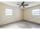 Bedroom featuring two windows, a ceiling fan, and terrazzo flooring at 5101 Town N Country Blvd, Tampa, FL 33615