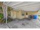 View of the home's carport with side entry doors and lush foliage at 5101 Town N Country Blvd, Tampa, FL 33615