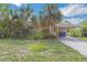Single-Gathering home with carport surrounded by tropical landscaping at 5101 Town N Country Blvd, Tampa, FL 33615
