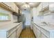 Efficient kitchen with white cabinetry, stainless steel refrigerator, and laminate countertops at 5101 Town N Country Blvd, Tampa, FL 33615