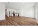 Open-concept living space with wood-look floors flows into kitchen featuring stainless steel appliances at 6174 Daerr Ridge St, Zephyrhills, FL 33542