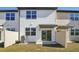 Townhome exterior featuring a backyard with grass, fence, and sliding glass doors at 6178 Daerr Ridge St, Zephyrhills, FL 33542