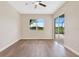 Spacious bedroom with a ceiling fan, sliding glass doors, and a view of the backyard at 11018 Pine Lilly Pl, Lakewood Ranch, FL 34202