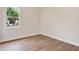 Bedroom with natural light, wood look flooring, white trim, and freshly painted walls at 11018 Pine Lilly Pl, Lakewood Ranch, FL 34202