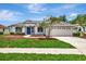 Charming single-story home with a manicured lawn, walkway, attached garage, and a striking blue front door at 11018 Pine Lilly Pl, Lakewood Ranch, FL 34202