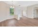 An open living space with a chandelier, hardwood flooring, and views through exterior windows at 11018 Pine Lilly Pl, Lakewood Ranch, FL 34202