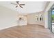 Open concept living room with recessed lights, wood look floors, ceiling fan, and sliding glass door at 11018 Pine Lilly Pl, Lakewood Ranch, FL 34202