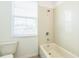 A bathroom with a white tiled tub and a window at 32717 Coldwater Creek Loop, Wesley Chapel, FL 33545