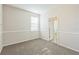 An empty bedroom is carpeted and has light colored walls and trim at 32717 Coldwater Creek Loop, Wesley Chapel, FL 33545