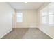 Empty carpeted bedroom with light colored walls and two windows at 32717 Coldwater Creek Loop, Wesley Chapel, FL 33545