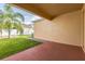 A covered patio overlooks a manicured lawn and a decorative palm tree at 32717 Coldwater Creek Loop, Wesley Chapel, FL 33545
